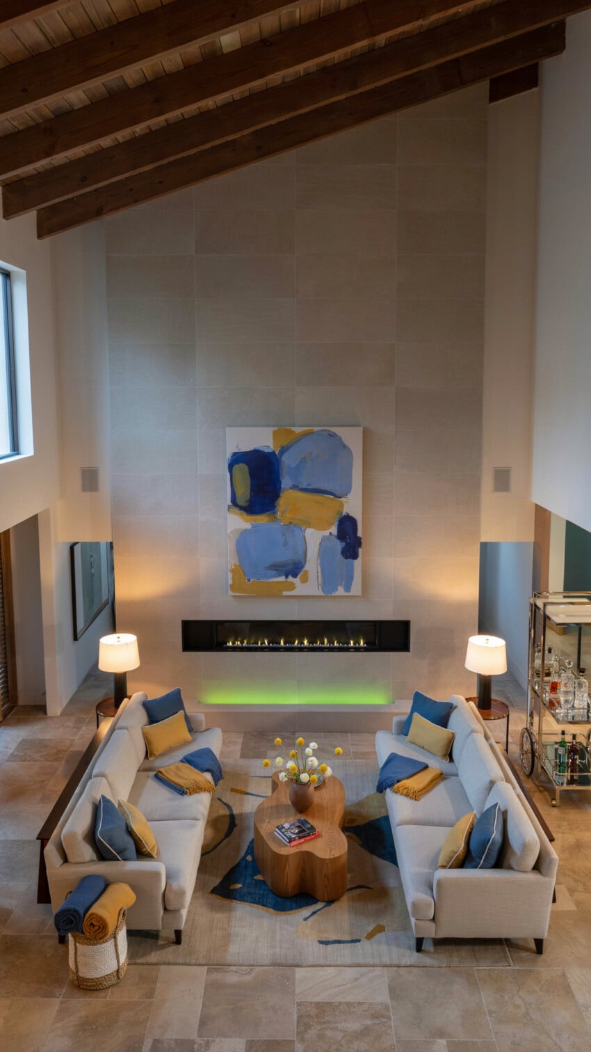 Limestone Tile Accent Wall with Cream Linen Sofas and Linear Fireplace